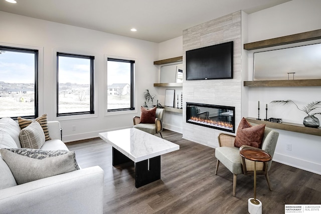 living room with dark wood-type flooring and a tile fireplace