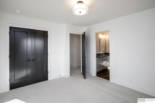 bedroom featuring ensuite bath, a closet, and dark colored carpet