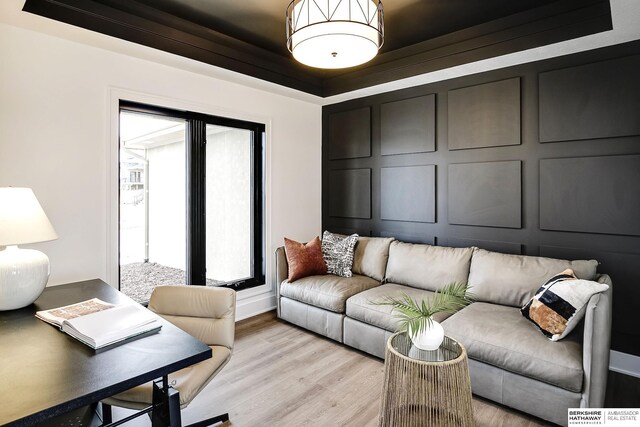 living room featuring light hardwood / wood-style flooring and a raised ceiling