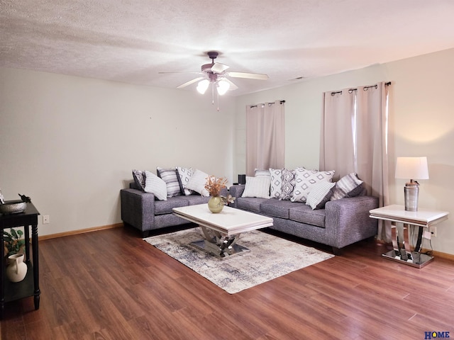 living room featuring ceiling fan, dark hardwood / wood-style floors, and a textured ceiling