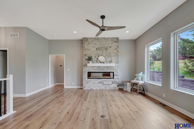 unfurnished living room with a healthy amount of sunlight, a fireplace, and light wood-type flooring