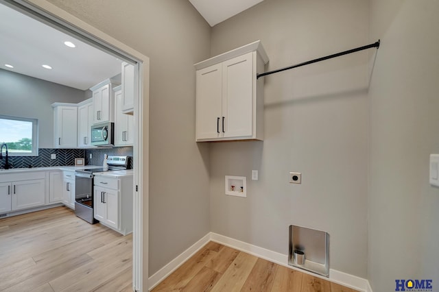 laundry area featuring washer hookup, sink, hookup for an electric dryer, and light hardwood / wood-style floors