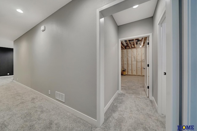 hallway featuring light colored carpet