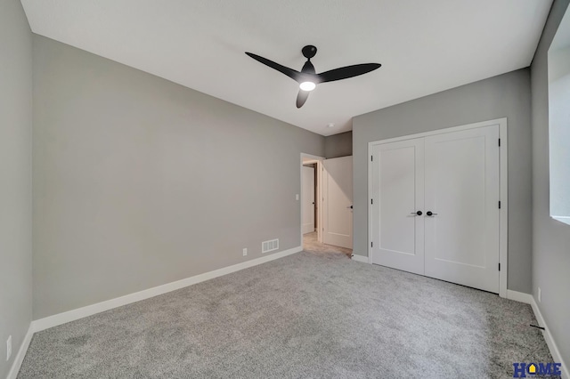 unfurnished bedroom featuring light carpet, ceiling fan, and a closet