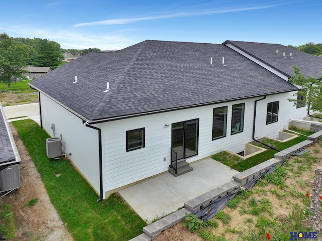 back of property featuring central AC unit, a yard, and a patio area