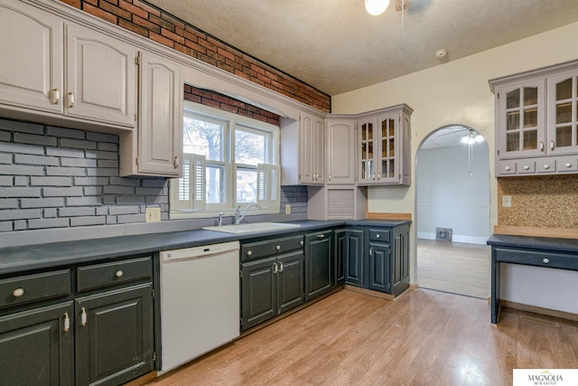 kitchen with dishwasher, sink, a textured ceiling, and decorative backsplash