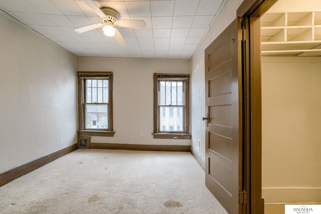 empty room featuring ceiling fan and light colored carpet