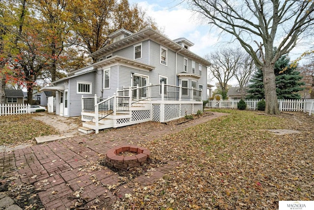 back of house featuring a patio area, a deck, and an outdoor fire pit