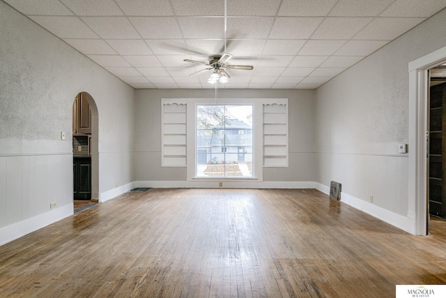 spare room with hardwood / wood-style flooring, a paneled ceiling, and ceiling fan