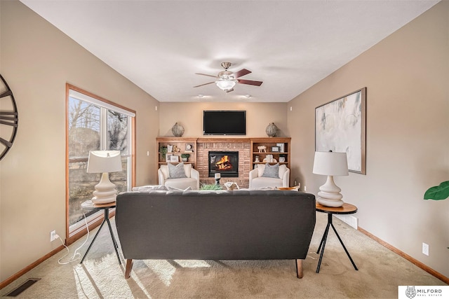 living room featuring ceiling fan, light colored carpet, and a brick fireplace