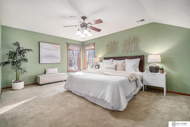 carpeted bedroom with ceiling fan, vaulted ceiling, and a textured ceiling