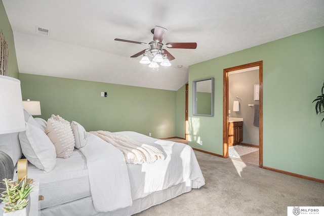 carpeted bedroom featuring ensuite bath, vaulted ceiling, and ceiling fan