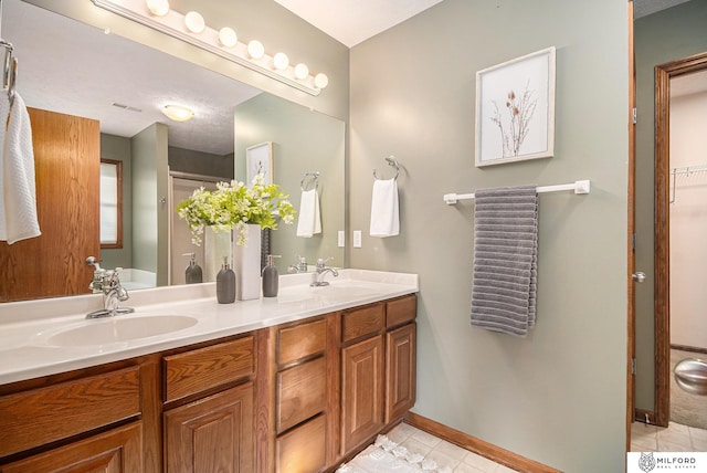 bathroom featuring vanity, tile patterned floors, and a shower