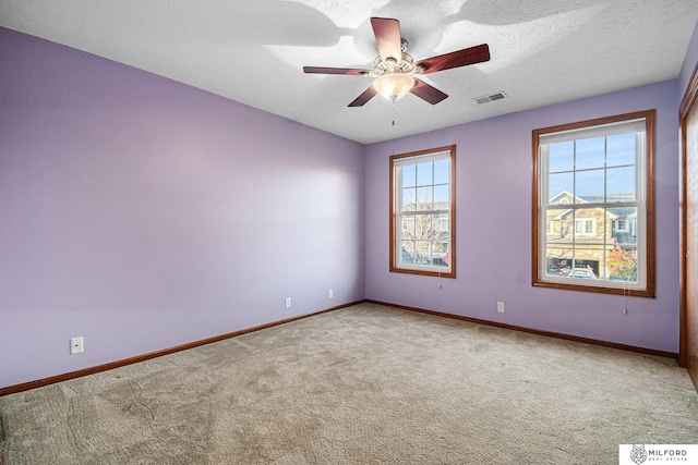 empty room with carpet floors, a textured ceiling, and ceiling fan