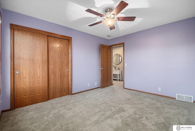 unfurnished bedroom with ceiling fan, light carpet, and a closet