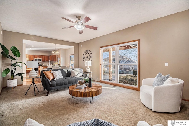 carpeted living room featuring ceiling fan with notable chandelier and a textured ceiling