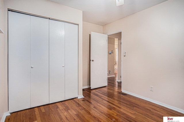 unfurnished bedroom featuring dark wood-type flooring and a closet