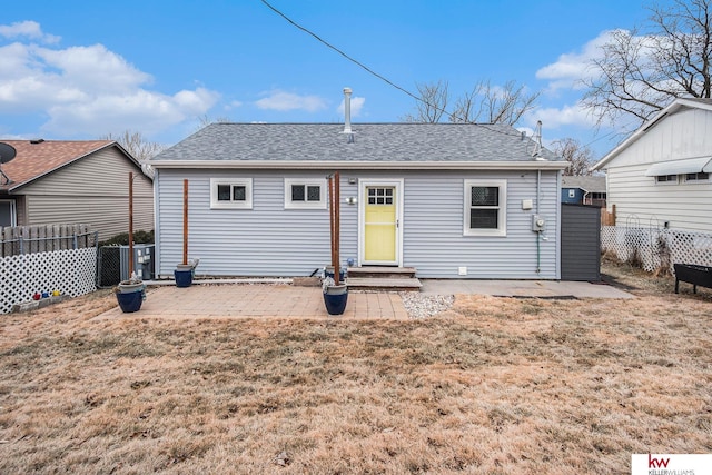 rear view of property featuring a yard, central AC unit, and a patio area