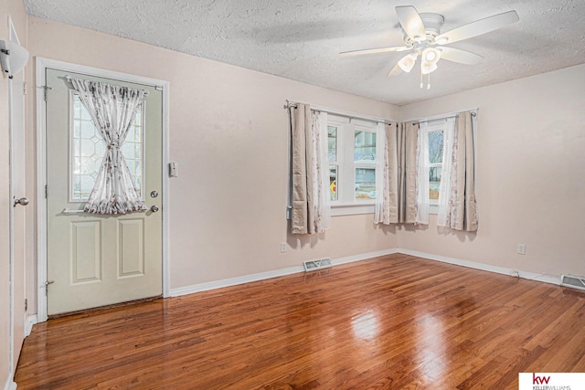 foyer entrance with a wealth of natural light, hardwood / wood-style floors, a textured ceiling, and ceiling fan