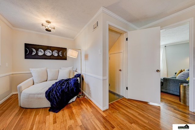 sitting room featuring crown molding, hardwood / wood-style flooring, and a textured ceiling