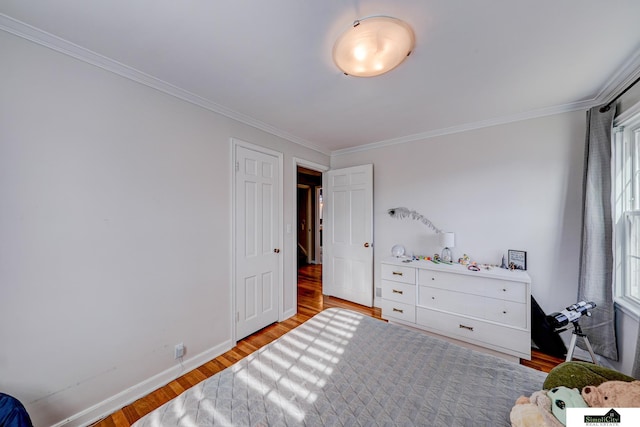 bedroom with crown molding and light hardwood / wood-style floors