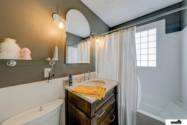 full bathroom featuring vanity, toilet, shower / bath combo with shower curtain, and a textured ceiling