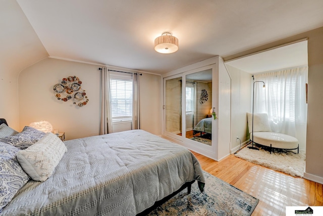 bedroom featuring hardwood / wood-style flooring and lofted ceiling