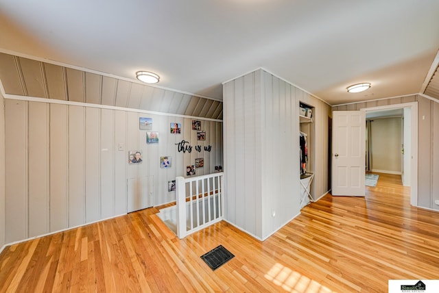 interior space with wood-type flooring and wood walls