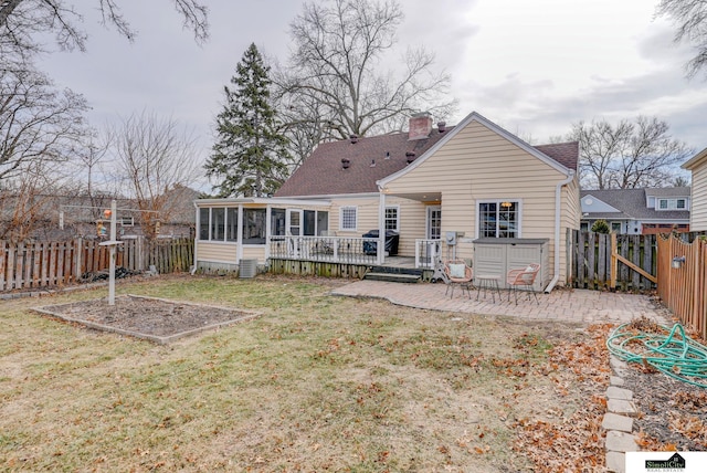 rear view of property with a sunroom, a yard, a deck, and a patio area