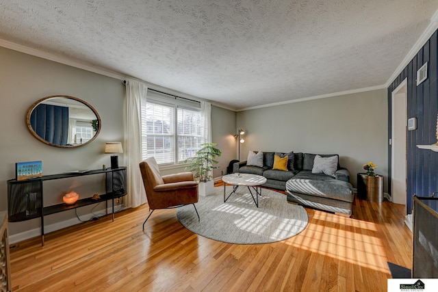 living room featuring ornamental molding, a textured ceiling, and light wood-type flooring