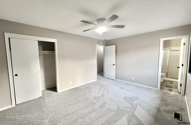 unfurnished bedroom with light colored carpet, a closet, ceiling fan, and ensuite bathroom