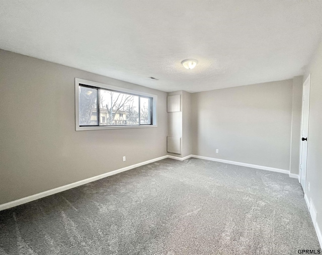 spare room with a textured ceiling and carpet flooring