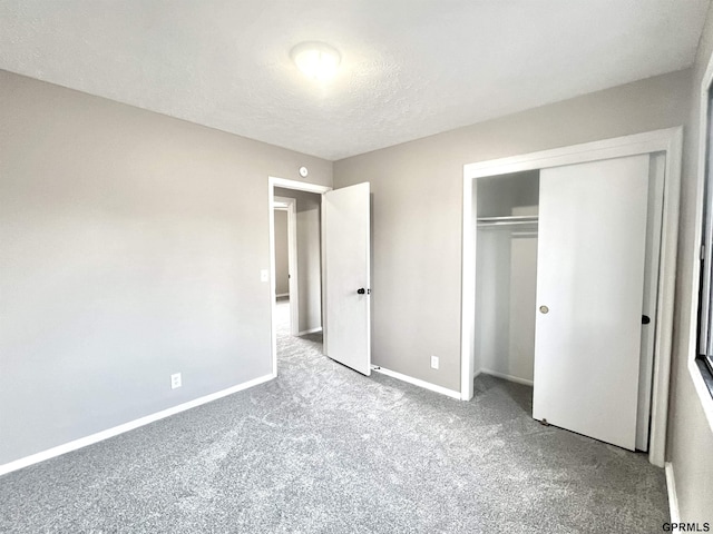 unfurnished bedroom with light colored carpet, a closet, and a textured ceiling