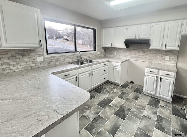 kitchen with white cabinetry, sink, and tasteful backsplash