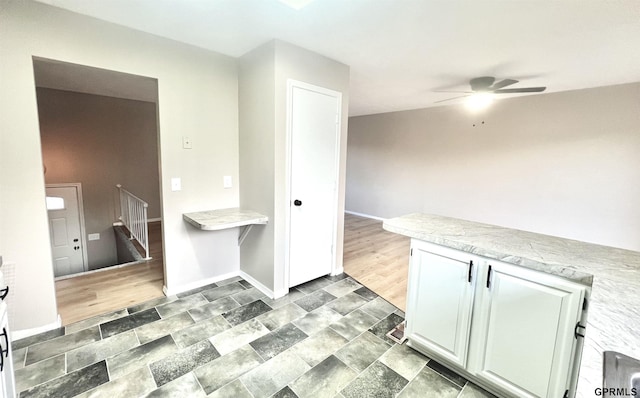 kitchen with ceiling fan and white cabinets