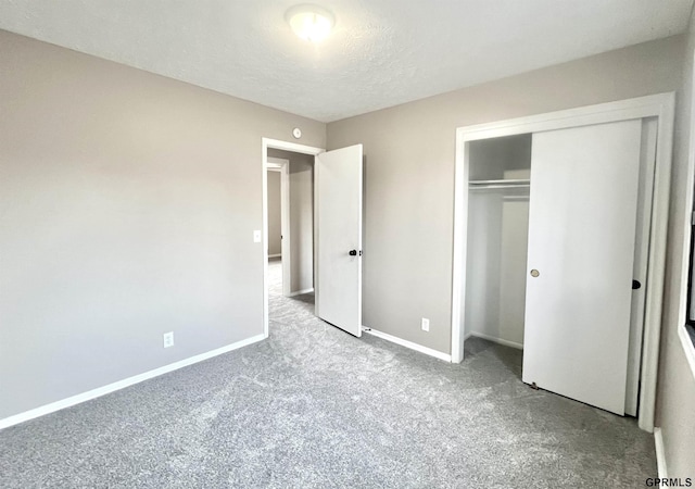 unfurnished bedroom with light colored carpet, a closet, and a textured ceiling