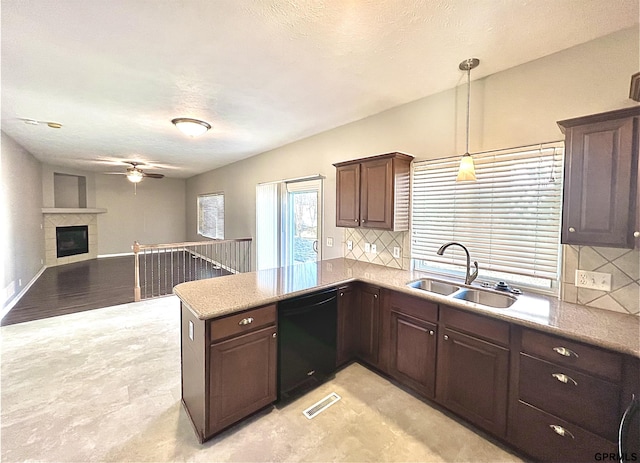 kitchen featuring pendant lighting, sink, dishwasher, tasteful backsplash, and kitchen peninsula