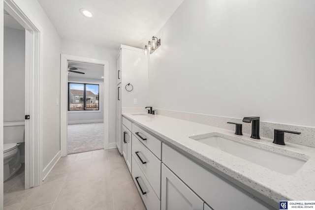 bathroom with vanity, toilet, tile patterned flooring, and a textured ceiling