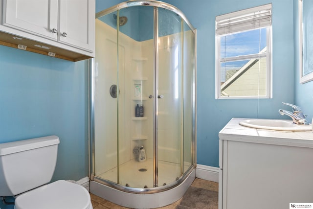 bathroom featuring vanity, tile patterned flooring, a shower with door, and toilet