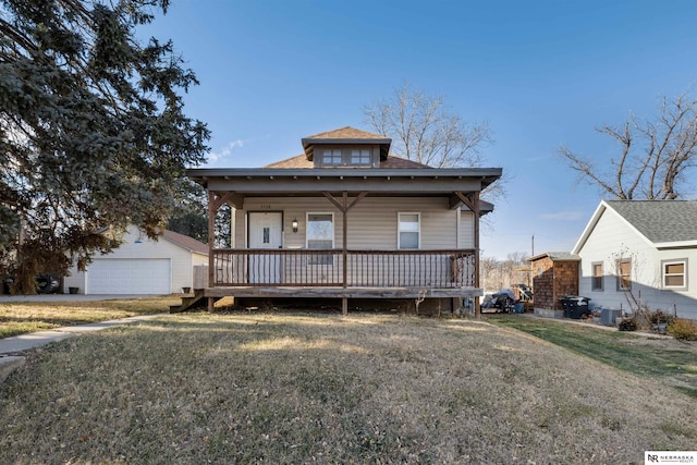 bungalow-style home with a garage, an outbuilding, cooling unit, and a front yard