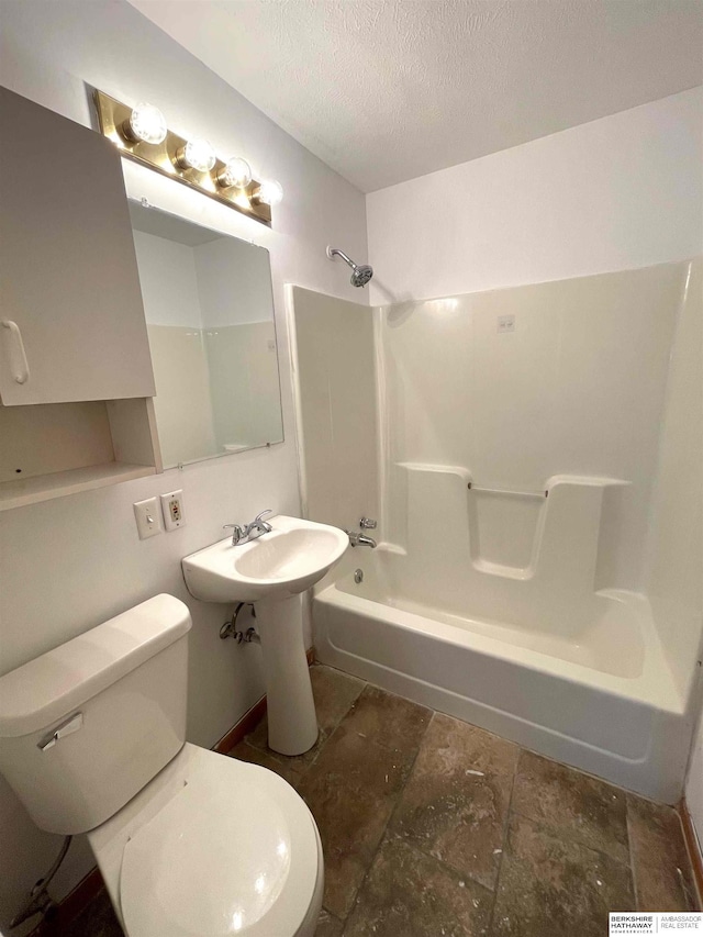 bathroom with shower / washtub combination, a textured ceiling, and toilet