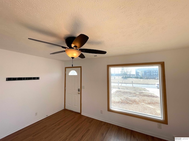 interior space with ceiling fan, wood-type flooring, and a textured ceiling