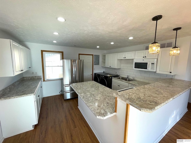 kitchen with hanging light fixtures, white cabinetry, a textured ceiling, and stainless steel refrigerator