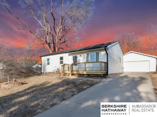 view of front of house with an outbuilding, a garage, and a deck