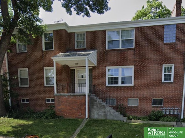 view of front facade featuring brick siding and a front lawn