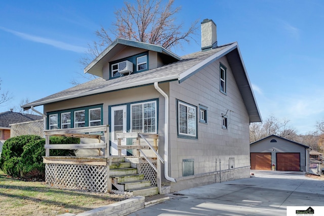 view of front of house featuring a garage, an outbuilding, and cooling unit