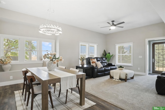 dining area with dark wood-type flooring and ceiling fan with notable chandelier