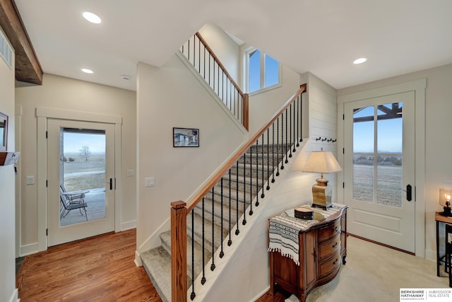 staircase with hardwood / wood-style flooring and a healthy amount of sunlight