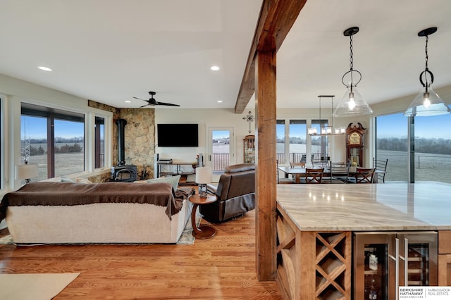interior space featuring plenty of natural light, a wood stove, wine cooler, and light wood-type flooring