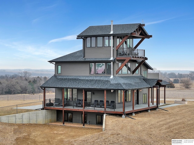 rear view of property featuring a yard and a balcony